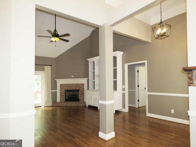 unfurnished living room with a brick fireplace, dark hardwood / wood-style flooring, high vaulted ceiling, and ceiling fan with notable chandelier