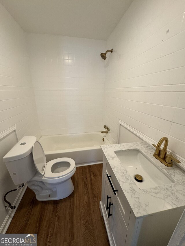 full bathroom with toilet, vanity, shower / bath combination, tile walls, and hardwood / wood-style flooring