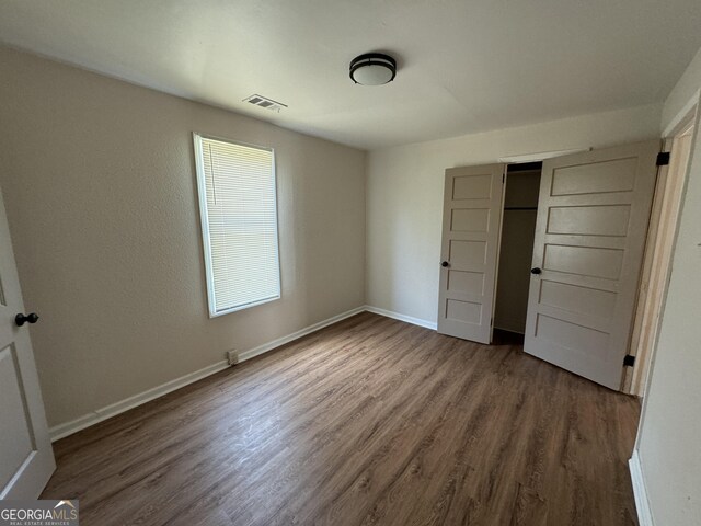 unfurnished bedroom with a closet and hardwood / wood-style floors