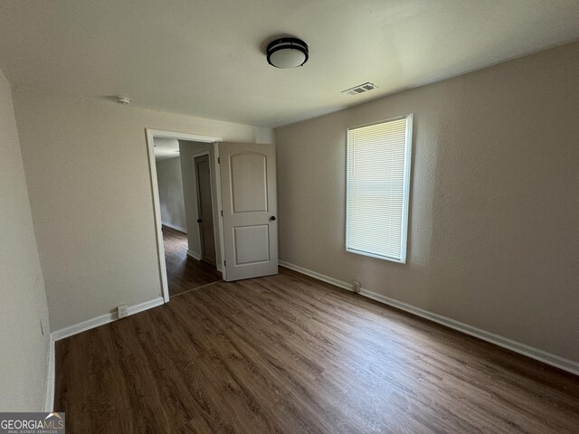 empty room featuring dark hardwood / wood-style flooring