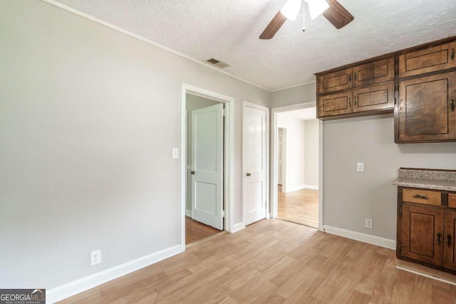 interior space with light wood-type flooring, a textured ceiling, and ceiling fan