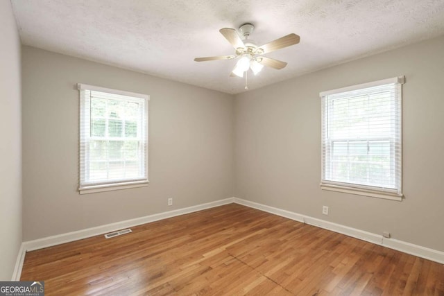 unfurnished room featuring a textured ceiling, ceiling fan, and hardwood / wood-style floors