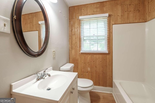 full bathroom with vanity, toilet, hardwood / wood-style flooring, independent shower and bath, and wooden walls