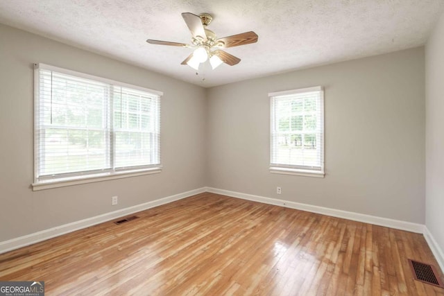 unfurnished room featuring a textured ceiling, light hardwood / wood-style flooring, and ceiling fan