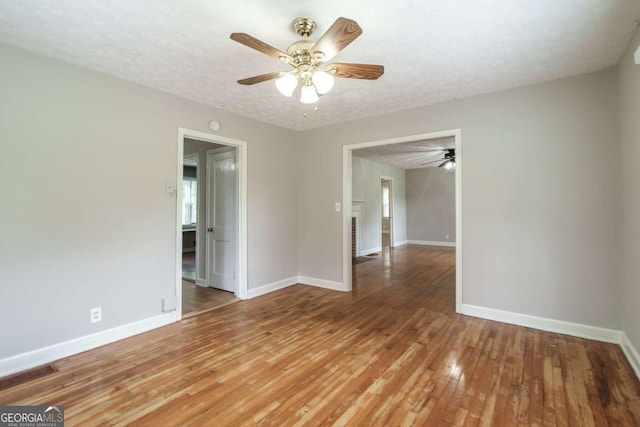 unfurnished room with a textured ceiling, hardwood / wood-style flooring, and ceiling fan