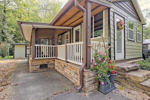 view of side of property featuring covered porch