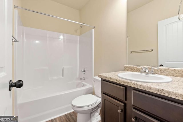 bathroom with shower / bathtub combination, wood finished floors, vanity, and toilet