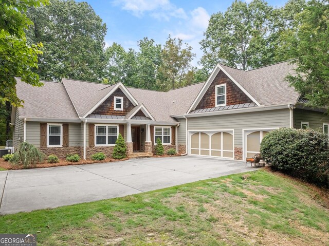 craftsman house featuring a garage and a front lawn