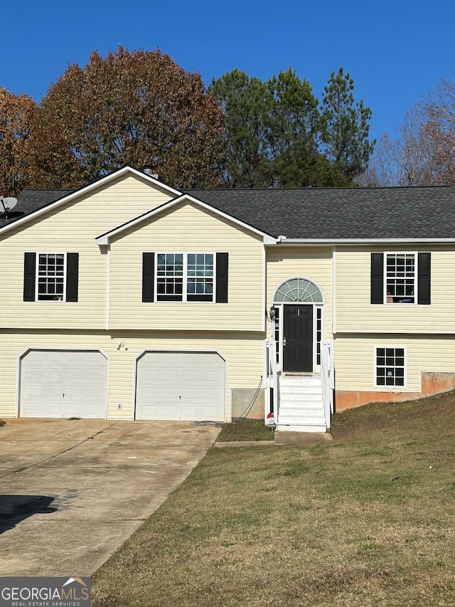 raised ranch with a garage and a front lawn