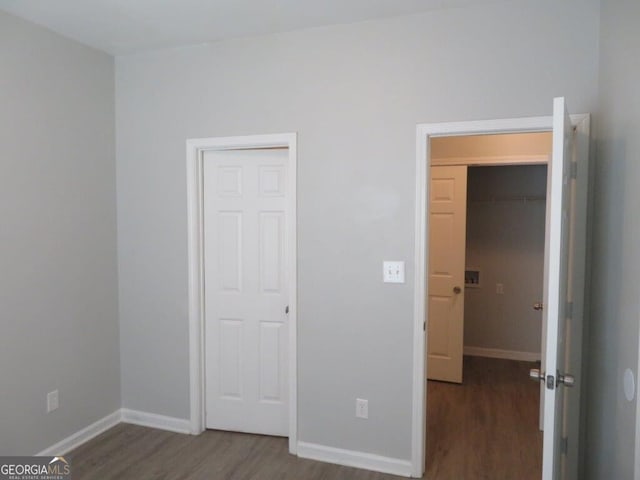 unfurnished bedroom featuring baseboards and dark wood-style floors