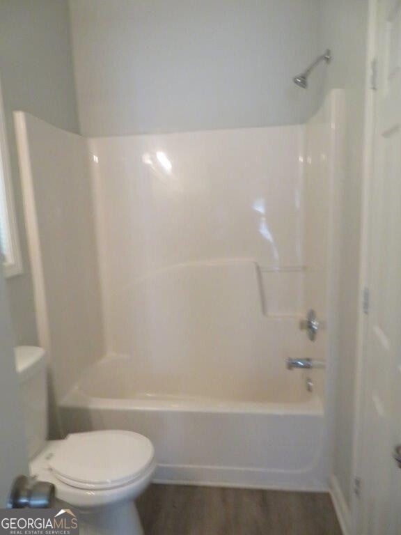 full bathroom featuring shower / bathing tub combination, toilet, and wood finished floors