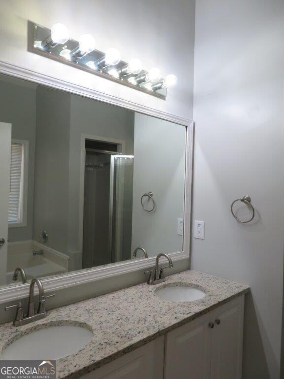 full bath with a sink, a shower, a garden tub, and double vanity