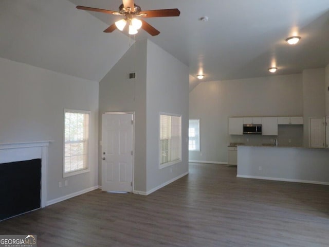 unfurnished living room featuring high vaulted ceiling, ceiling fan, and wood-type flooring