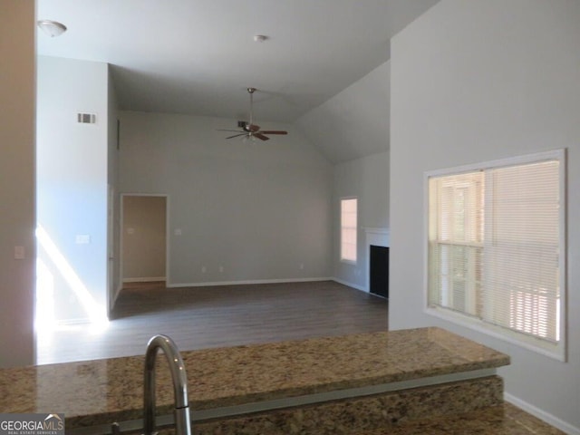 interior space featuring visible vents, high vaulted ceiling, wood finished floors, a fireplace, and ceiling fan