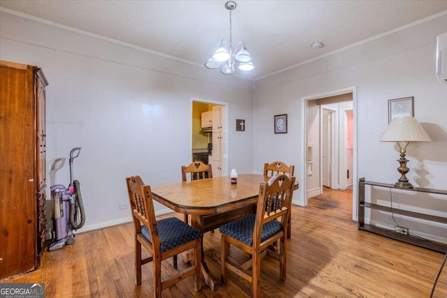 dining space with crown molding, a textured ceiling, a notable chandelier, and light hardwood / wood-style floors