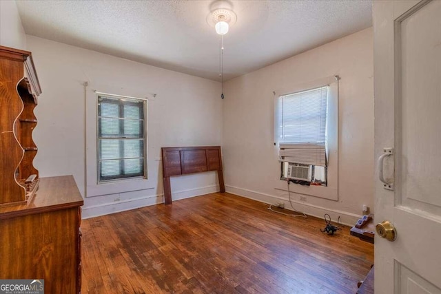 unfurnished room with a textured ceiling and hardwood / wood-style flooring