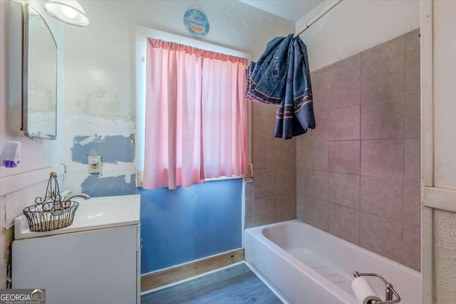 bathroom featuring tiled shower / bath, hardwood / wood-style flooring, and vanity