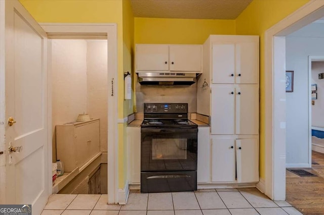 kitchen featuring black electric range, white cabinets, a textured ceiling, and light hardwood / wood-style flooring