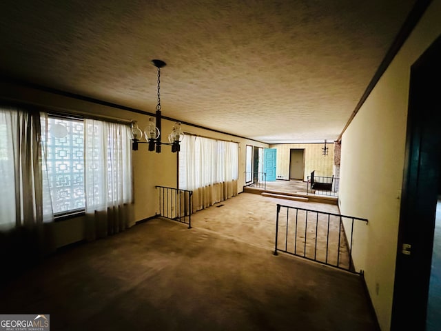 interior space featuring carpet flooring, a notable chandelier, and a textured ceiling