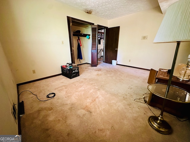 unfurnished bedroom with light carpet and a textured ceiling