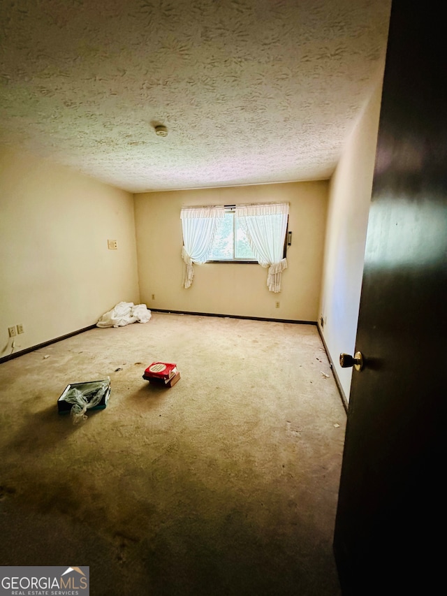 carpeted empty room with a textured ceiling