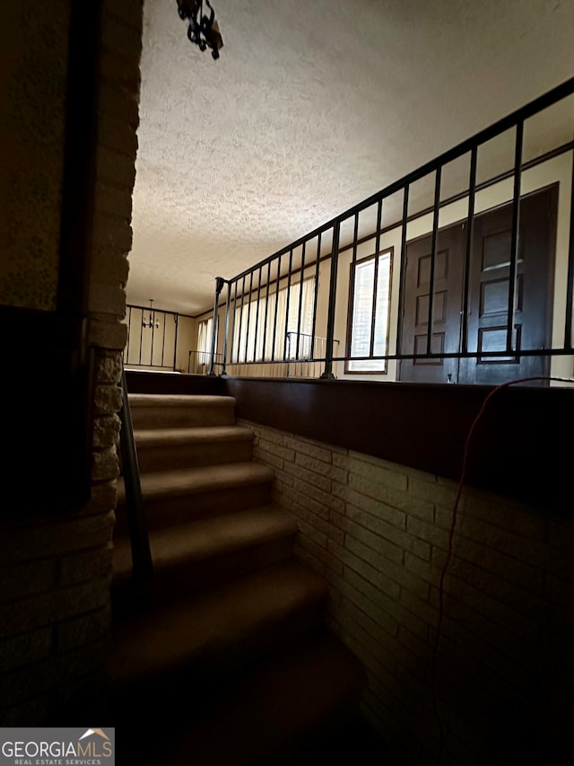 staircase with a textured ceiling