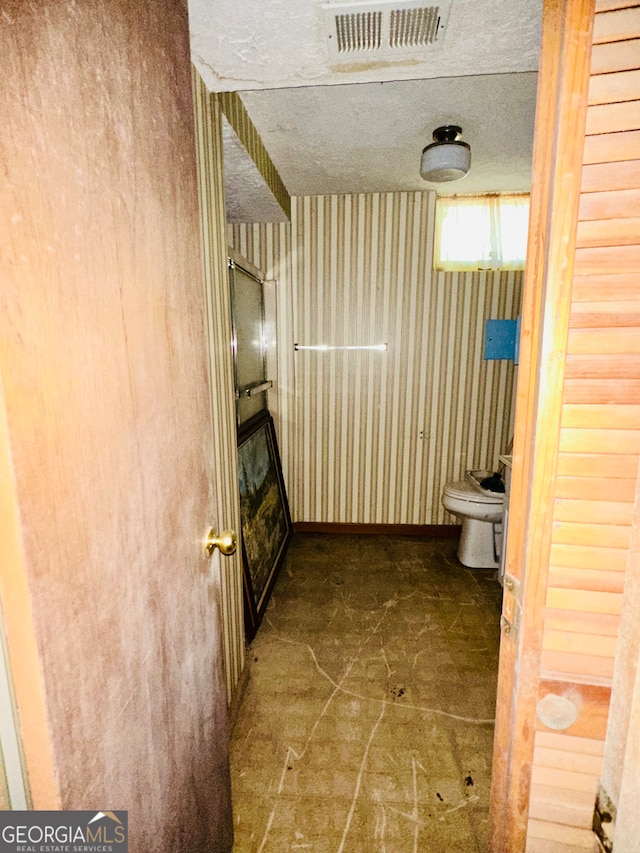 bathroom featuring a textured ceiling and toilet