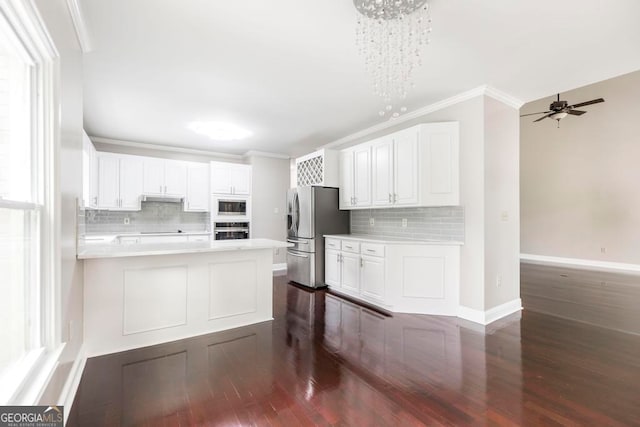 kitchen featuring dark wood-type flooring, tasteful backsplash, stainless steel appliances, and white cabinetry