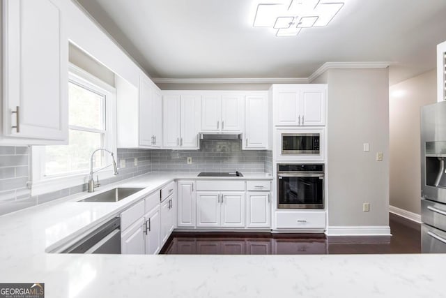 kitchen with dark hardwood / wood-style floors, tasteful backsplash, stainless steel appliances, sink, and white cabinets