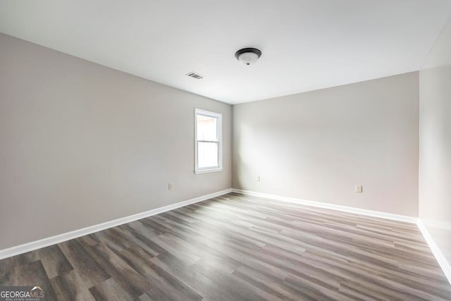 unfurnished room with dark wood-type flooring