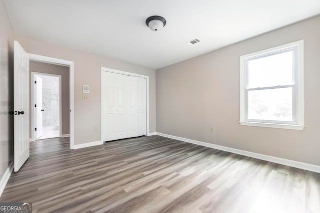 unfurnished bedroom featuring hardwood / wood-style flooring and a closet