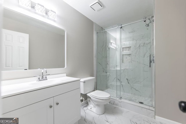 bathroom featuring a shower with door, vanity, and toilet