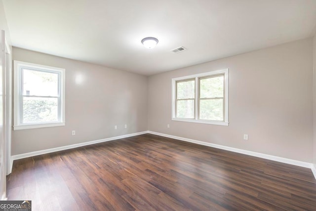 unfurnished room with dark hardwood / wood-style flooring