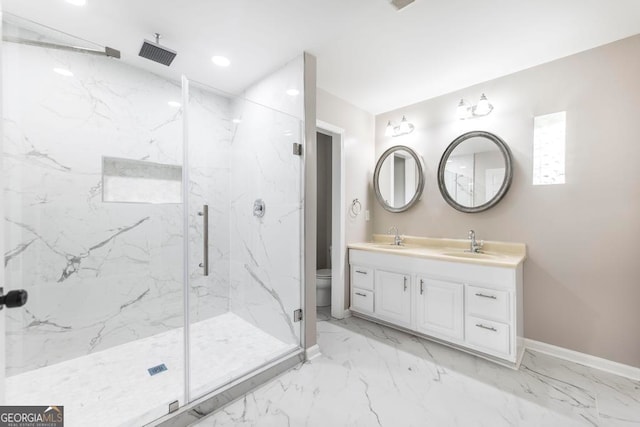 bathroom featuring a shower with door, vanity, and toilet