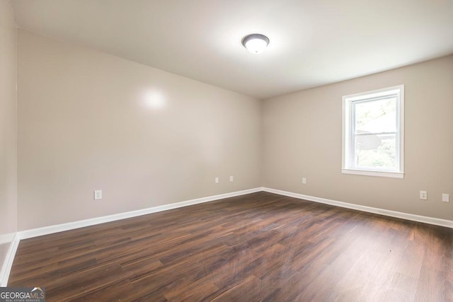 empty room with dark hardwood / wood-style flooring