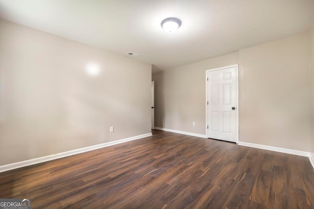 unfurnished room with dark hardwood / wood-style flooring