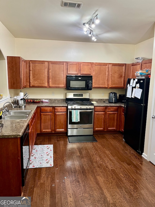 kitchen with black appliances, dark hardwood / wood-style floors, sink, and track lighting