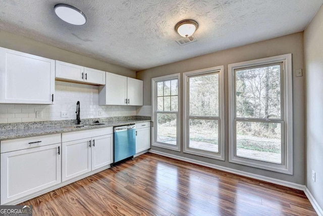 kitchen featuring white cabinetry, plenty of natural light, and stainless steel dishwasher