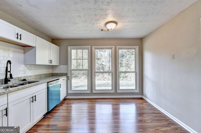 kitchen with stainless steel dishwasher, a healthy amount of sunlight, sink, and decorative backsplash