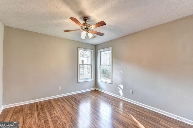 unfurnished room with dark wood-type flooring, ceiling fan, and a textured ceiling