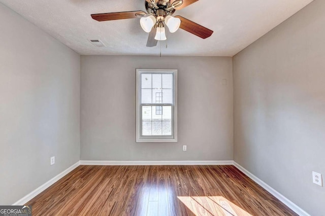 empty room with a textured ceiling, hardwood / wood-style floors, and ceiling fan