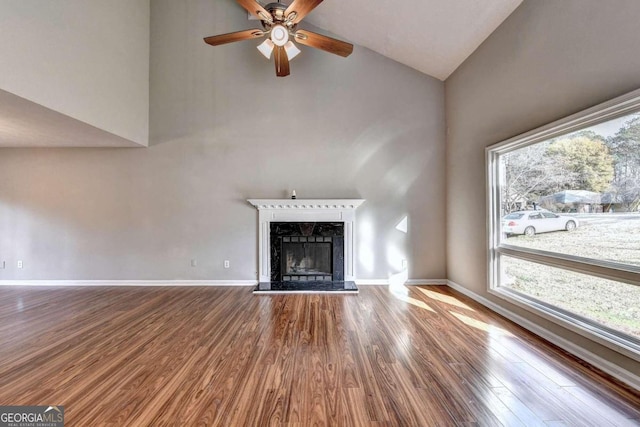 unfurnished living room with high vaulted ceiling, ceiling fan, hardwood / wood-style flooring, and a fireplace