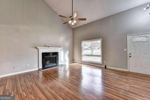 unfurnished living room with high vaulted ceiling, ceiling fan, hardwood / wood-style flooring, and a fireplace