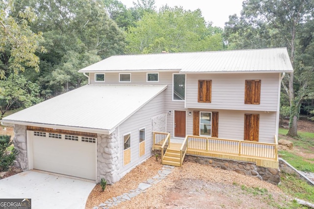 view of front of property with stone siding, metal roof, driveway, and an attached garage