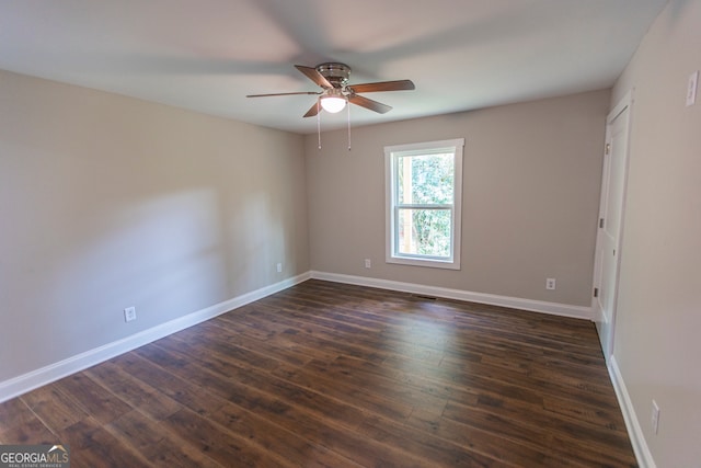 empty room with dark wood-type flooring and ceiling fan