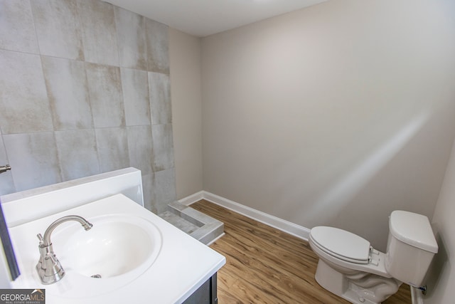 bathroom with hardwood / wood-style floors, toilet, and vanity