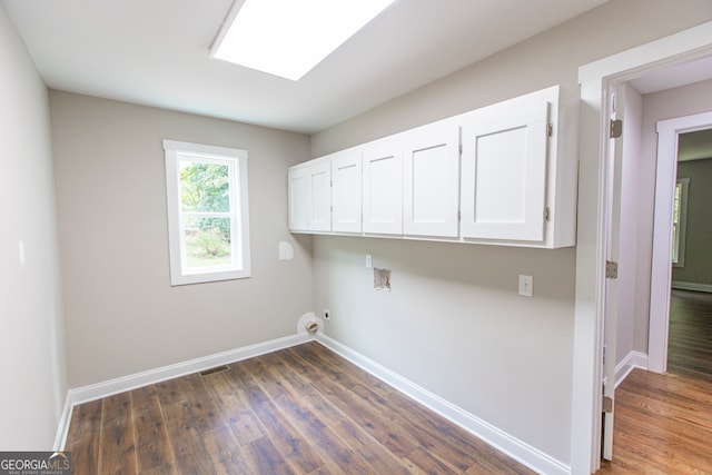 washroom featuring hookup for a washing machine, cabinets, and dark hardwood / wood-style flooring