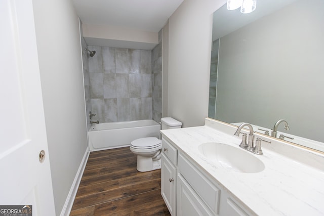 full bathroom featuring wood-type flooring, toilet, tiled shower / bath combo, and vanity