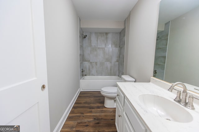 full bathroom with tiled shower / bath combo, toilet, hardwood / wood-style flooring, and vanity