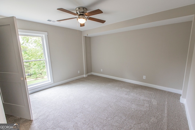 spare room with ceiling fan and light carpet